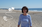 Manuela Weinand am Strand mit einem Symbol für den Weg vom Start bis zum Ziel.